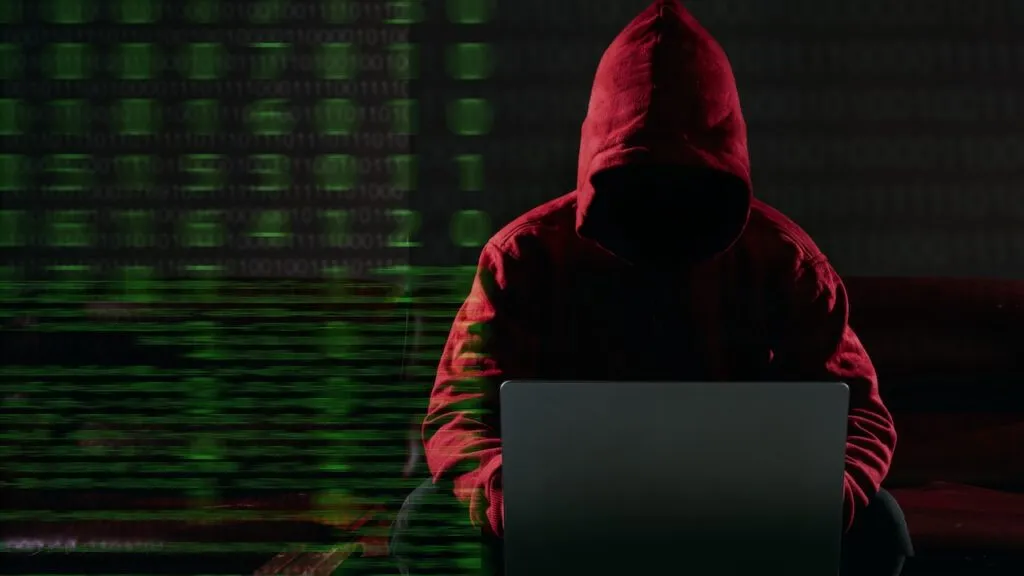 Hacking and malware concept. Hacker using laptop computer with binary code digital interface.