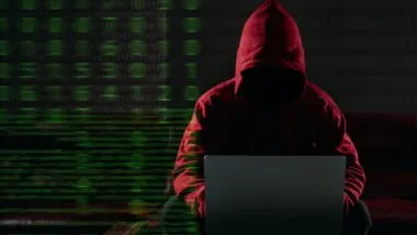 Hacking and malware concept. Hacker using laptop computer with binary code digital interface.