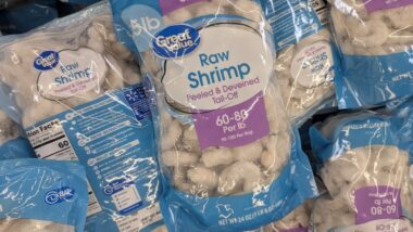 A Stack Of Great Value Raw Shrimp Bags In A Grocery Freezer