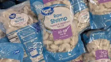 A Stack Of Great Value Raw Shrimp Bags In A Grocery Freezer