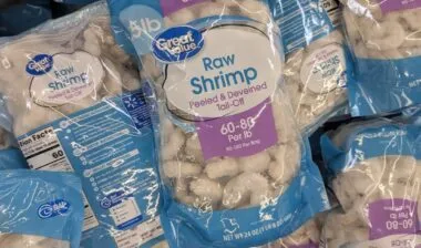 A Stack Of Great Value Raw Shrimp Bags In A Grocery Freezer