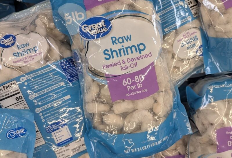 A Stack Of Great Value Raw Shrimp Bags In A Grocery Freezer
