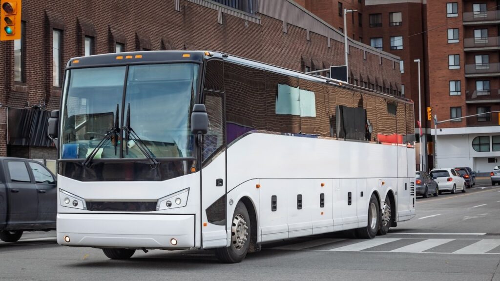 A large intercity motorcoach turns through an urban intersection in an american city