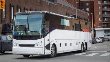 A large intercity motorcoach turns through an urban intersection in an american city