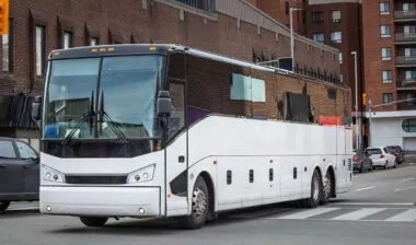 A large intercity motorcoach turns through an urban intersection in an american city